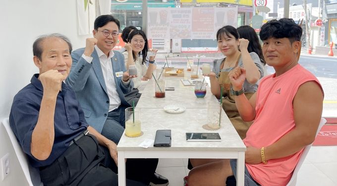 이용욱 의원(사진 왼쪽에서 가운데)과 임유진 대표(오른쪽 뒷줄) 등이 단디한입 메뉴를 들고 기념 촬영을 했다.