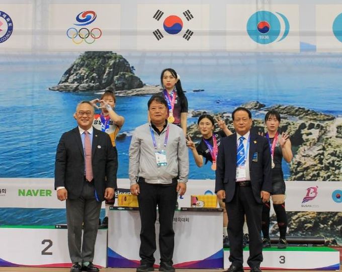 수상대에서 금메달을 걸고 선수들과 기념사진 찍는 신재경 선수(수상대 왼쪽 2번째)