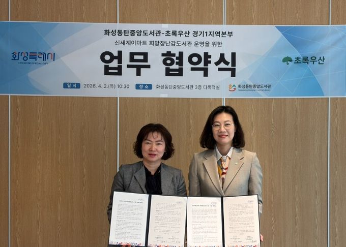 화성동탄중앙도서관과 초록우산 경기1지역본부 관계자들이 ‘신세계이마트 희망장난감도서관’ 운영 업무협약을 체결하고 협약서를 들어 보이며 기념촬영을 하고 있다